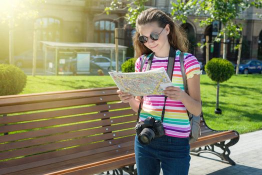 Happy girl teen tourist travel holding camera and map