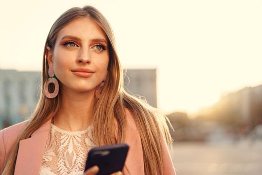 Close up portrait of a young woman talking on her phone in the street. Close up.