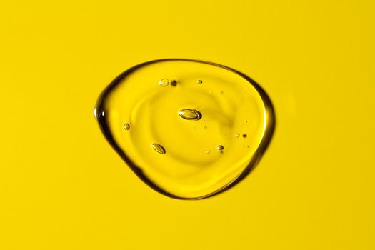 Clear transparent round liquid gel drop or smear isolated on yellow background. Top view. Virus protection or cosmetics concept. Serum texture