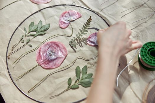 Confident female florist is working with dryed flowers in cozy flower shop