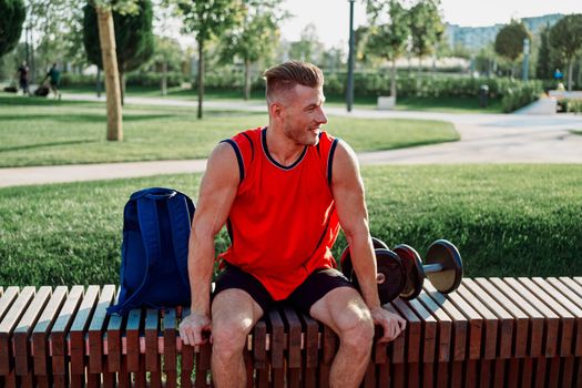 athletic man in red t-shirt in fitness park. High quality photo