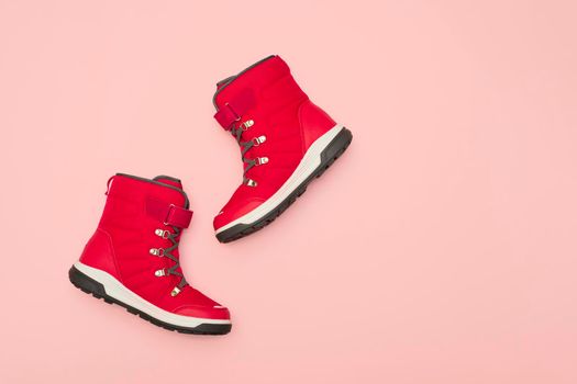 Kids or teenage pink winter boots isolated on pink background. Winter boots for girls