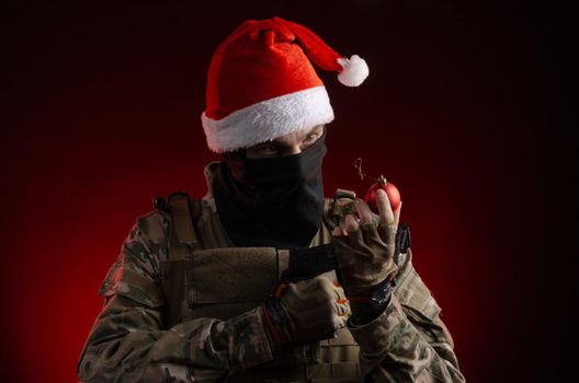 the man in a military uniform with a gun and a Santa Claus hat