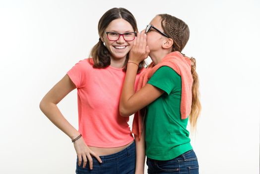 Portrait of two 12-13 year old girls. Beautiful teenage girlfriends communicate, secrete and smiling