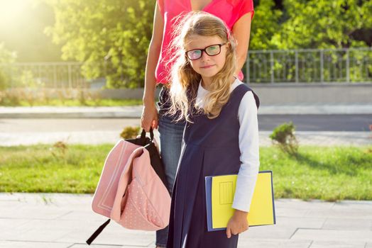 Mother walking to school with children. Back to school