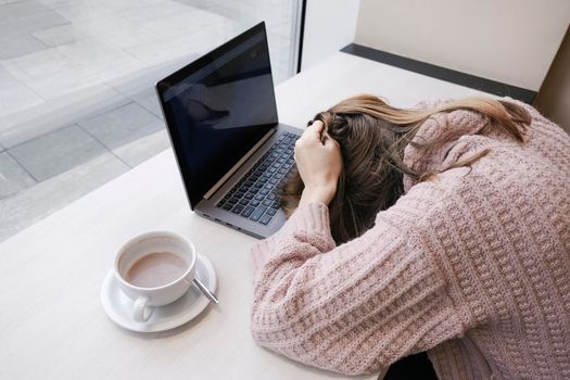 Tired young woman office worker put her head on the office desk. Office employee burnout concept. Working or education from coworking top view banner with copy space.