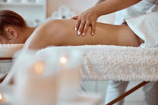 Professional confident massage master is doing procedures to caucasian woman in minimalistic modern cabinet