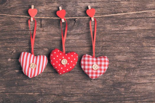 White and red sewed christmas hearts attached to the rope. Holiday background for greetings Valentine's day