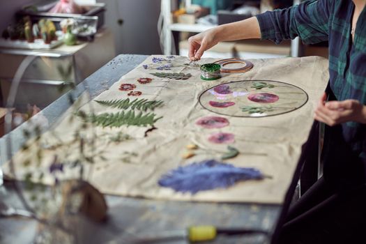 Confident female florist is working with dryed flowers in cozy flower shop