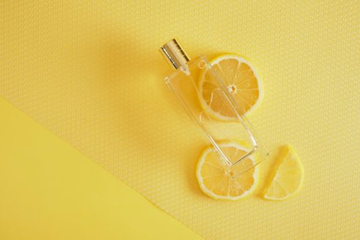 citrus scent, perfume with lemon scent concept, lemon wedges and a bottle of perfume copy space