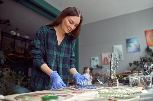 Confident female florist is working with dryed flowers in cozy flower shop