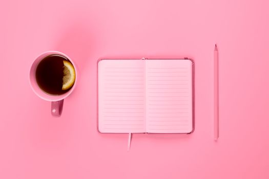 Tea cup and fancy notebook with empty or blank page on desk from above, planning and design concept. Top view, flat lay, copy space. Mock up toned in pink.