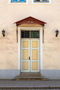 Wooden door with decoration elements in old building facade. Tallinn, Estonia. Colorful timber antique door