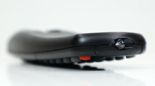 Remote control close-up. Black TV remote control with AAA alkaline batteries on a white background. Battery replacement, spare parts