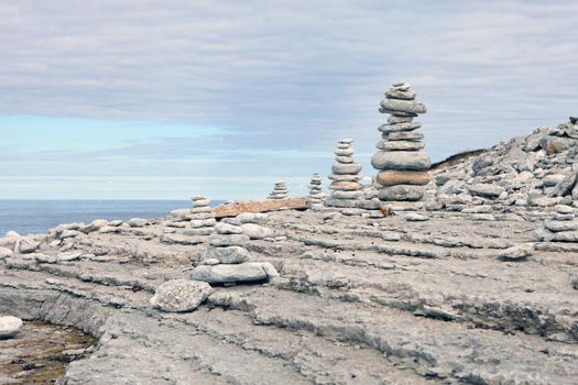 Stones balance, pebbles stack over blue sea in Estonia in Osmussaar iceland. Blue sky on sunny baltic coast in summer.