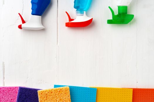 Home cleaning supplies on white wooden background, top view photo