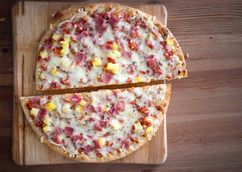 Cuttedhomemade pizza slices. Delicious italian pizza served on wooden table