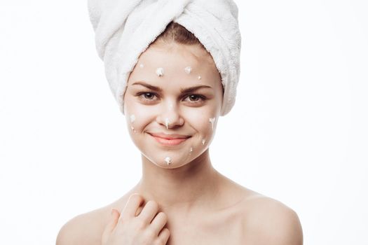 cheerful woman with a white towel on her head face cream skin care. High quality photo