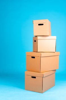 Stack of cardboard boxes on blue background. Close up.