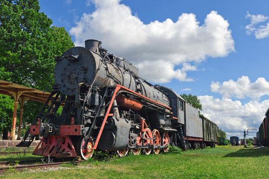 HAAPSALU, ESTONIA - July 30, 2020: Railway Museum in the town of Haapsalu. In the foreground is the old locomotive and the train station. Scene photographed in the autumn season. Estonian haapsalu railway