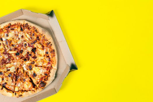 Tasty hawaii pizza in a box isolated on yellow Top view on paperoni pizza. Concept for italian food, street food, fast food, quick bite. Banner with copy space