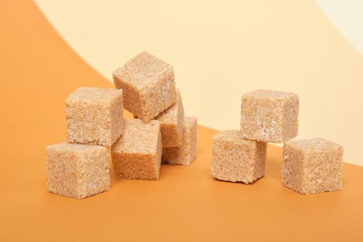brown sugar cane cubes on brown background, trend color place copy, roll paper, beige background