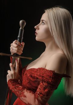 lovely girl in red dress with sword posing on black background in Studio (blonde )