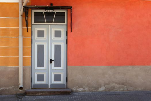 Wooden door with decoration elements in old building facade. Tallinn, Estonia. Colorful timber antique door