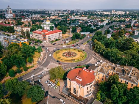 Aerial view of roundabout road with circular cars in small european city at summer afternoon, Kyiv region, Ukraine