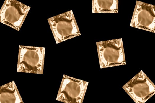 Pattern made from golden condoms on black background. Safe sex concept