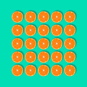 Fruit pattern of fresh mandarin slices isolated on blue or mint background. Flat lay, top view. Pop art design, creative summer concept. Half of tangerine citrus in minimal style.