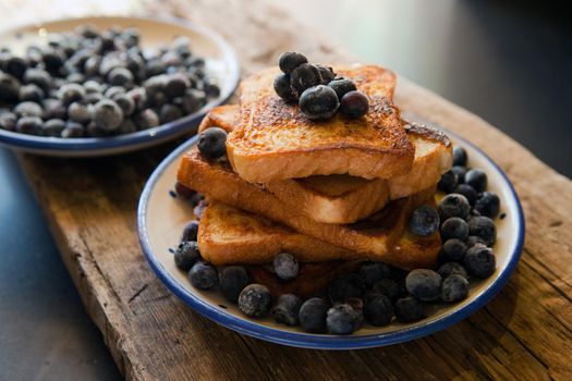French toast with berries blueberries, strawberries and sauce, traditional sweet dessert of bread with egg and milk. Morning baking food. toasted bread with bluberries