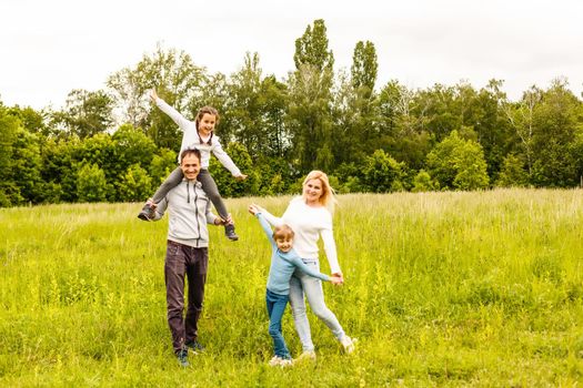 Happy family enjoying life together at meadow outdoor.