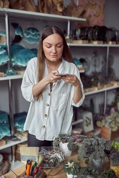 Young caucasian happy seller woman at botanic shop