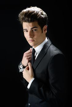 Portrait of a young businessman, isolated on black background