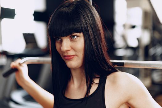 Close up photo of a young sporty woman working out in a gym