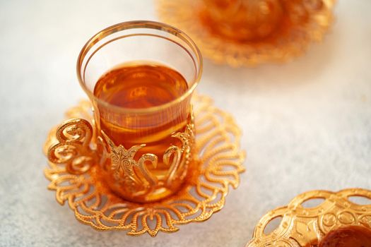 Turkish baklava and Turkish tea in oriental dishes on gray background, close up