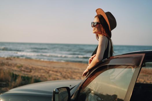 pretty woman in sunglasses near the car on the beach travel lifestyle. High quality photo