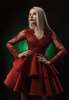 lovely girl in red dress posing on black background in Studio (blonde )