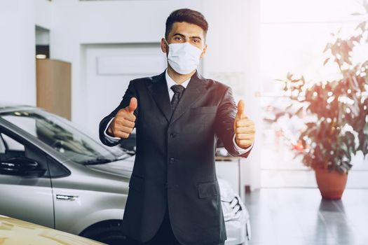 Man car dealer wearing protective medical mask on his working place, coronavirus prevention concept