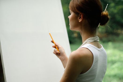 woman outdoors painting a picture creative art landscape. High quality photo
