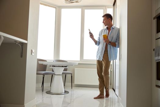 Happy beautiful handsome smiling caucasian man is relaxing at modern light home