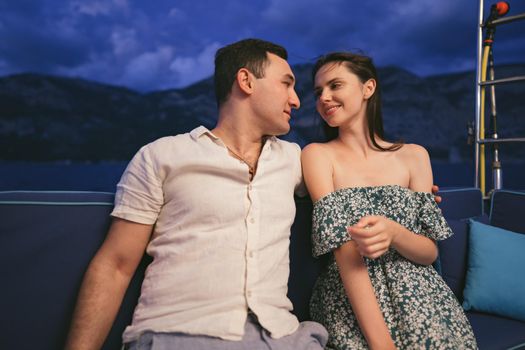 Portrait of happy loving couple on the yacht in the evening