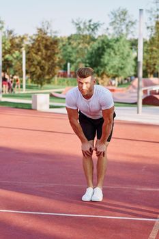 man in white t-shirt on the sports ground workout motivation. High quality photo