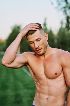 man with pumped up muscular body outdoors health workout. High quality photo