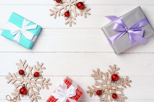 Christmas gifts and decorations on white wooden board, top view