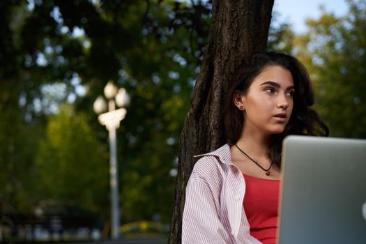 woman with laptop sitting on the grass Lifestyle Fresh air. High quality photo