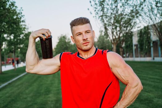 sporty man in the park outdoors glass with drink. High quality photo