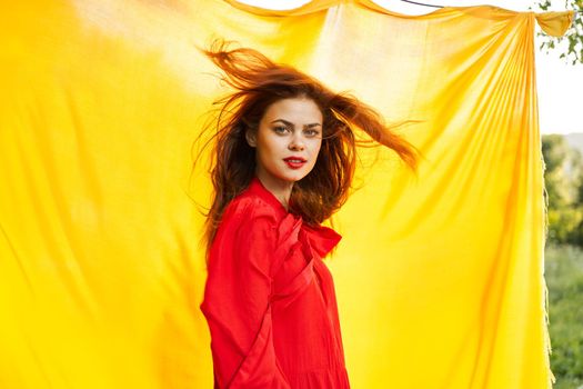 pretty woman in red dress outdoors nature yellow cloth. High quality photo