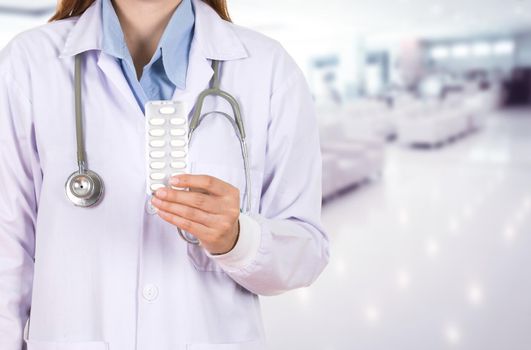 female doctor holding with pills in hospital background